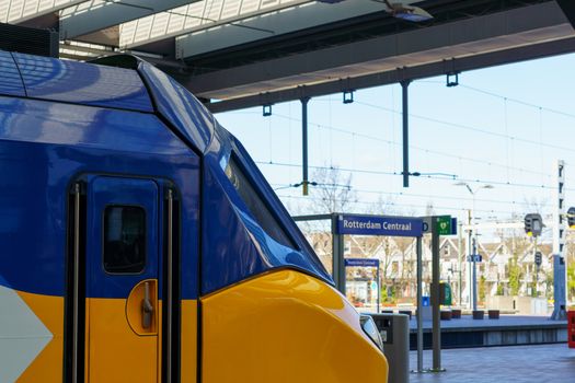Voorkant van wijchen station met fietsenstalling en reizigers bij de ingang